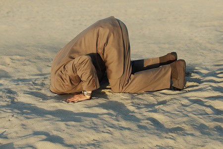 image of a man with head in sand to symbolize avoidance