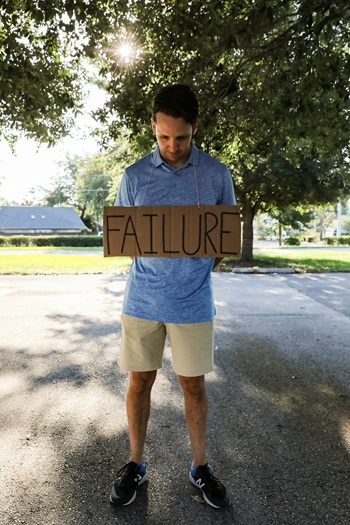 image of a man holding a sign that says failure to conceptualize the notion of personal responsibility